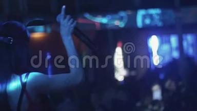 后面的MC女孩在兔子面具舞蹈在舞台上的夜总会。 举起双手。 表演节目